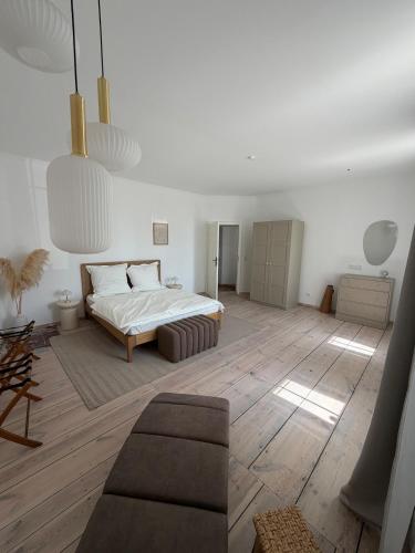 a bedroom with a bed and a couch in it at Altes Lehmhaus Löwenberg in Linde