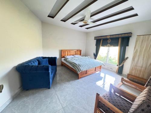 a bedroom with a bed and a blue couch at Ember Guest House in Abbottabad