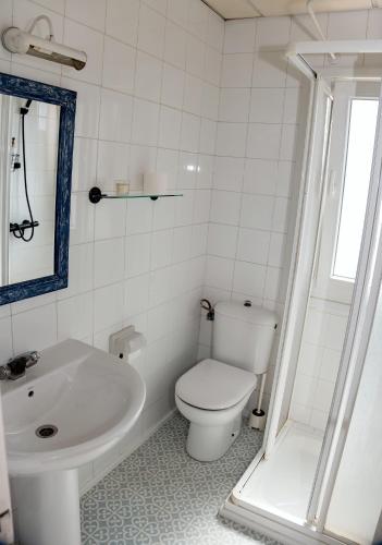 a white bathroom with a toilet and a sink at Villa Pepe, casa compartida in Pontevedra