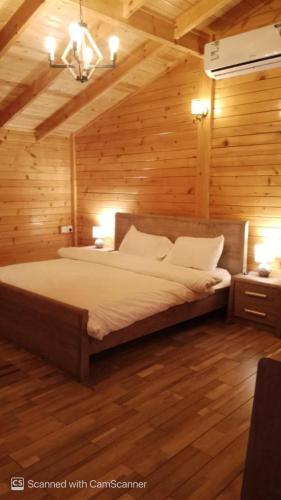 a bedroom with a large bed in a wooden room at كوخ بحانز الأول in Taif