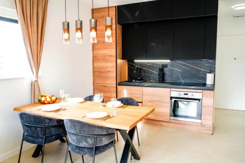 a kitchen with a wooden table and blue chairs at Luxury Apartment Mara in Sukošan