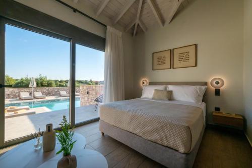 ein Schlafzimmer mit einem Bett und einem großen Fenster in der Unterkunft Koroni Poolside Suites in Koroni