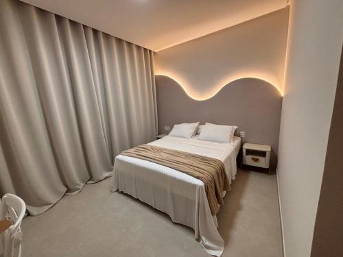 a bedroom with a bed and a large window at My Way Flat in Aracati