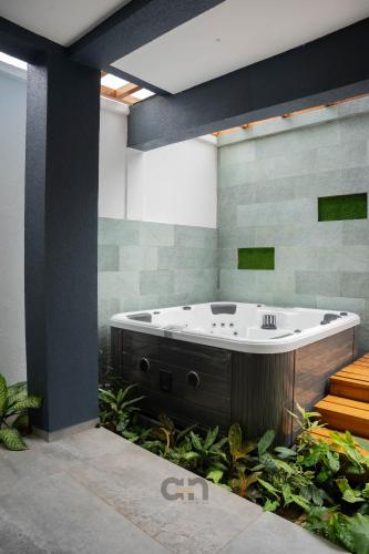 a large bath tub in a room with plants at Villa BOCANIA in Cotonou