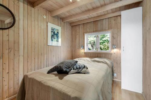 a bedroom with wooden walls and a bed with a pillow at C11248-Hemmet-Ildervej-26 in Hemmet