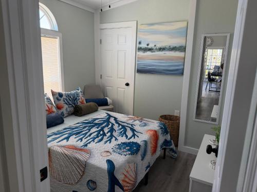 a bedroom with a bed with a colorful comforter at Tami Beach Resort Rental in Fort Myers Beach