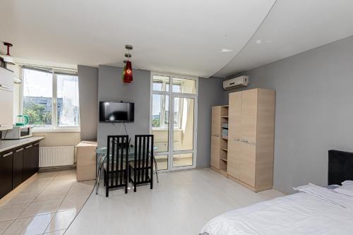a bedroom with a bed and a table and chairs at Columna Residence in Chişinău