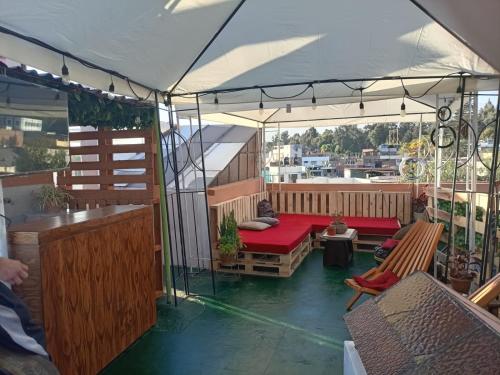 a screened in porch with a red couch and chairs at Il Riposo in Arequipa