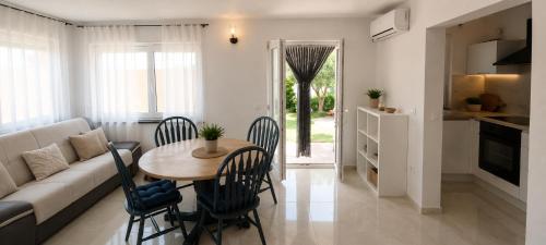 a living room with a table and chairs and a couch at Apartments Beba in Privlaka
