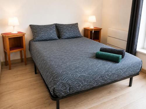 a bed in a room with two night stands and two lamps at La Tanière Enchantée de Tréhorenteuc • Brocéliande in Tréhorenteuc