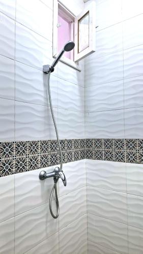 a shower head in a bathroom with a tiled wall at Dar Aziz in Sousse