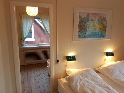 a bedroom with two beds and a window at Budget Guesthouse Borgustova in Vestmanna