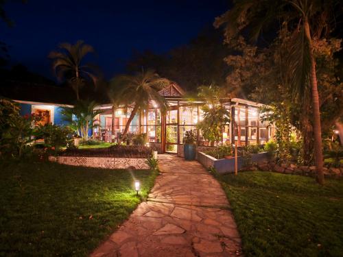 a house at night with a pathway in front of it at Xalli Beach Hotel in Altagracia