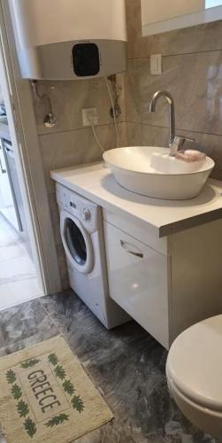 a bathroom with a sink and a washing machine at Lana in Paralia Katerinis