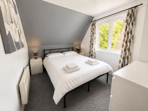 a bedroom with a white bed and a window at 47 Trevithick Court in Hayle