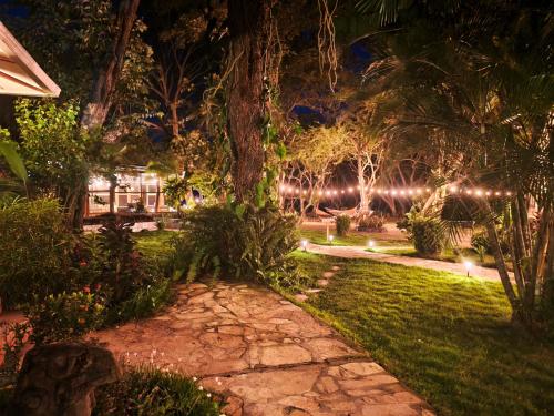 a garden at night with lights at Xalli Beach Hotel in Altagracia