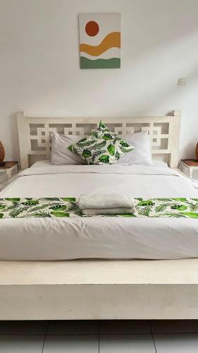 a large white bed with a wooden headboard at Casavina residen kubu manyar 202 in Dalung