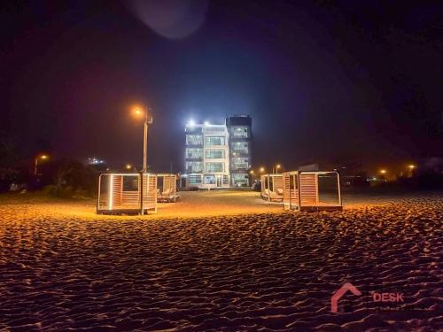 a beach at night with a building in the background at Beachfront Escape Pool Hot Tub and Fire pit in Montañita