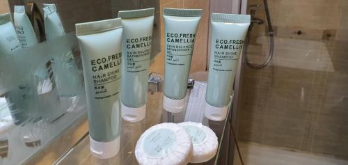 a group of four bottles of lotion on a glass shelf at Beach Resort Salalah in Salalah