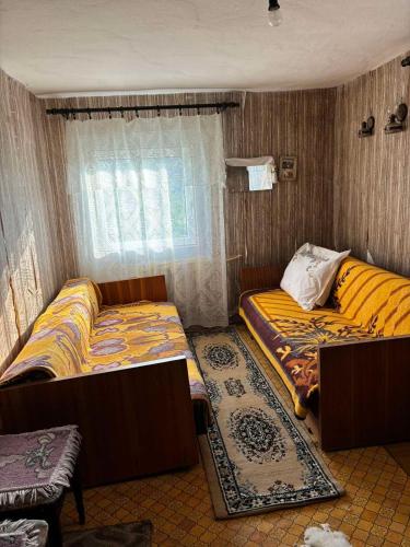 a room with two beds and a window at Etno kuća Močioci in Ivanjica