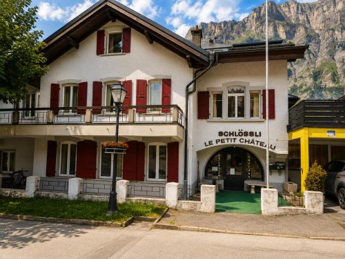 a building with a mountain in the background at Schlossli-Le Petit Chateau in Leukerbad