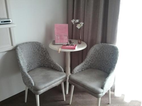 two chairs and a table in a room with a table at Pensiunea Rustik Lancram in Sebeş