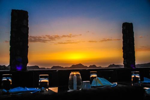 a table with a view of the sunset at Tetra Tree Hotel in Wadi Musa