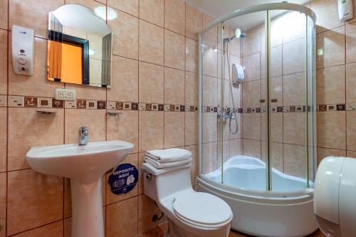 a bathroom with a toilet and a sink and a shower at Hotel Majestic 1 Centro Histórico Cuenca in Cuenca