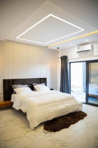 a large bedroom with a large bed with white sheets at Villa CICAS in Cotonou