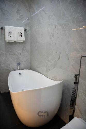 a white bath tub sitting in a bathroom at Villa CICAS in Cotonou