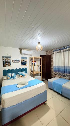 a bedroom with two beds and a chandelier at Pousada Recanto das Fontes in Beberibe