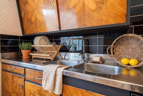 a kitchen with a sink and wooden cabinets at Snertingdal ysteri in Gjøvik