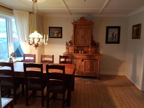 a dining room with a table and chairs and a chandelier at Budget Guesthouse Borgustova in Vestmanna