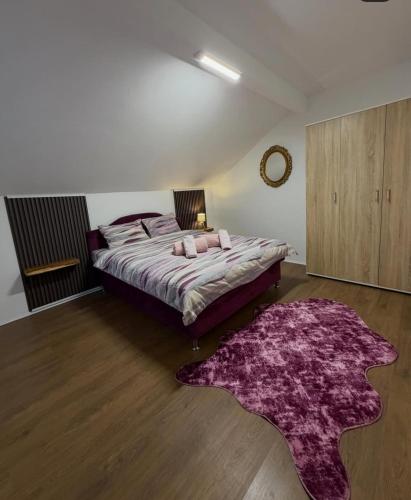 a bedroom with a large bed with a purple rug at Filip in Sarajevo
