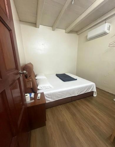 a small room with a bed and a door at Nangyang lodge in Malacca
