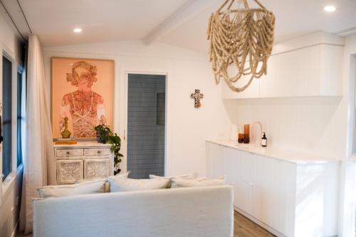 a living room with a white couch and a chandelier at ROSINA Beach Shack in Bellbrae