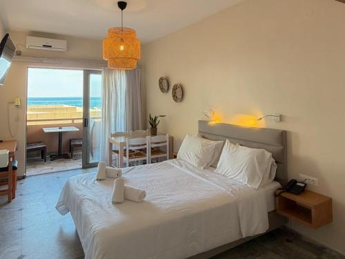a bedroom with a bed with a view of the ocean at Ariadne Beach in Platanias