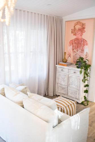 a living room with a white couch and a dresser at ROSINA Beach Shack in Bellbrae