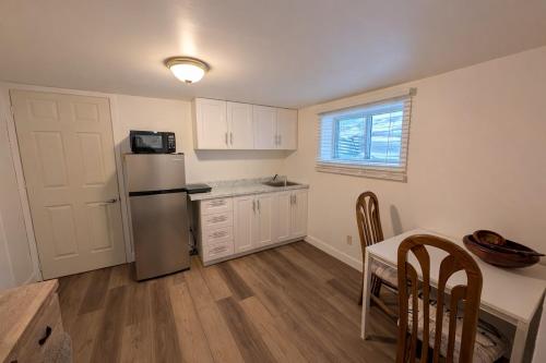 a kitchen with a refrigerator and a table with chairs at Countryside studio on a lake in Bic