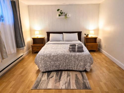 a bedroom with a bed and two nightstands and two tables at Countryside studio on a lake in Bic