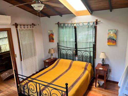 a bedroom with a bed and two night stands and two windows at Kliffstone Jungle House in Sayab Camp