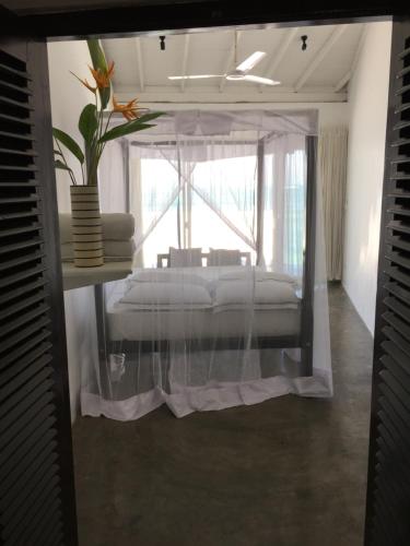 a bedroom with a bed in a room with a window at Galle Henna Beach House in Unawatuna