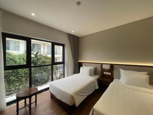 a hotel room with two beds and a window at Mariha Hotel Ninh Bình in Ða Gia