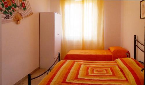 ボルゲット・サント・スピーリトにあるAppartamento Stella Marisのベッド2台と窓が備わる小さな客室です。