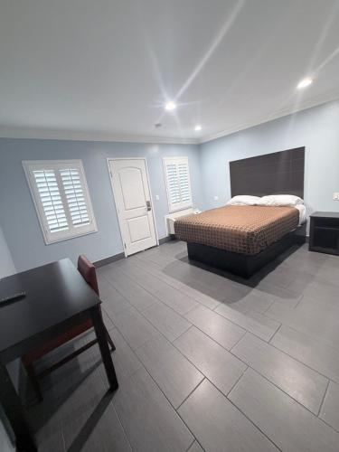 a bedroom with a bed and a table and a desk at Coronado Motel in Long Beach