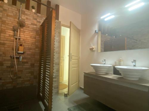 a bathroom with two sinks and a shower at L'isménia, Le Loft in Le Gosier