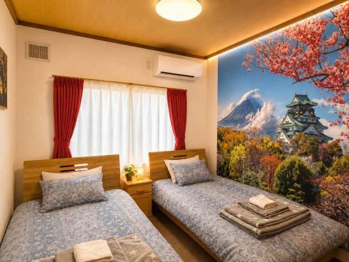 a bedroom with two beds and a painting of a mountain at Horomisou in Noboribetsu