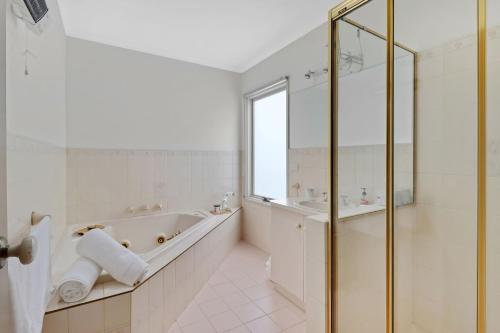 a white bathroom with a tub and a sink at Seven Views in Clifton Springs