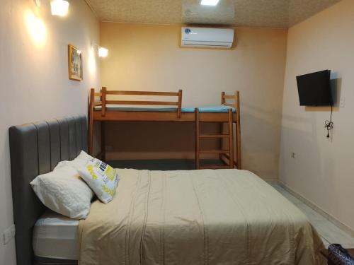 a small bedroom with a bed and a desk at Mi Hábitat Lambaré - Habitaciones con Baño Privado, Cocina y Comedor equipados con electrodomésticos, con Quincho al Aire Libre in Asunción