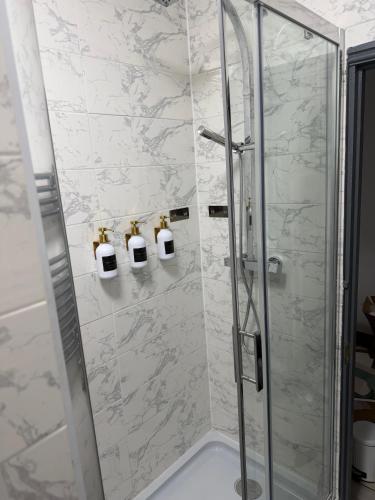 a bathroom with a shower with a glass door at GS Maisons Hideaway in Sheffield